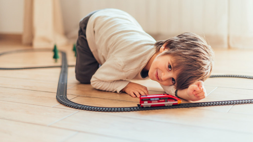 Ein Kind spielt mit einem Zug auf dem Boden. Wissen Sie, welche Weichmacher in Bodenbelägen stecken?